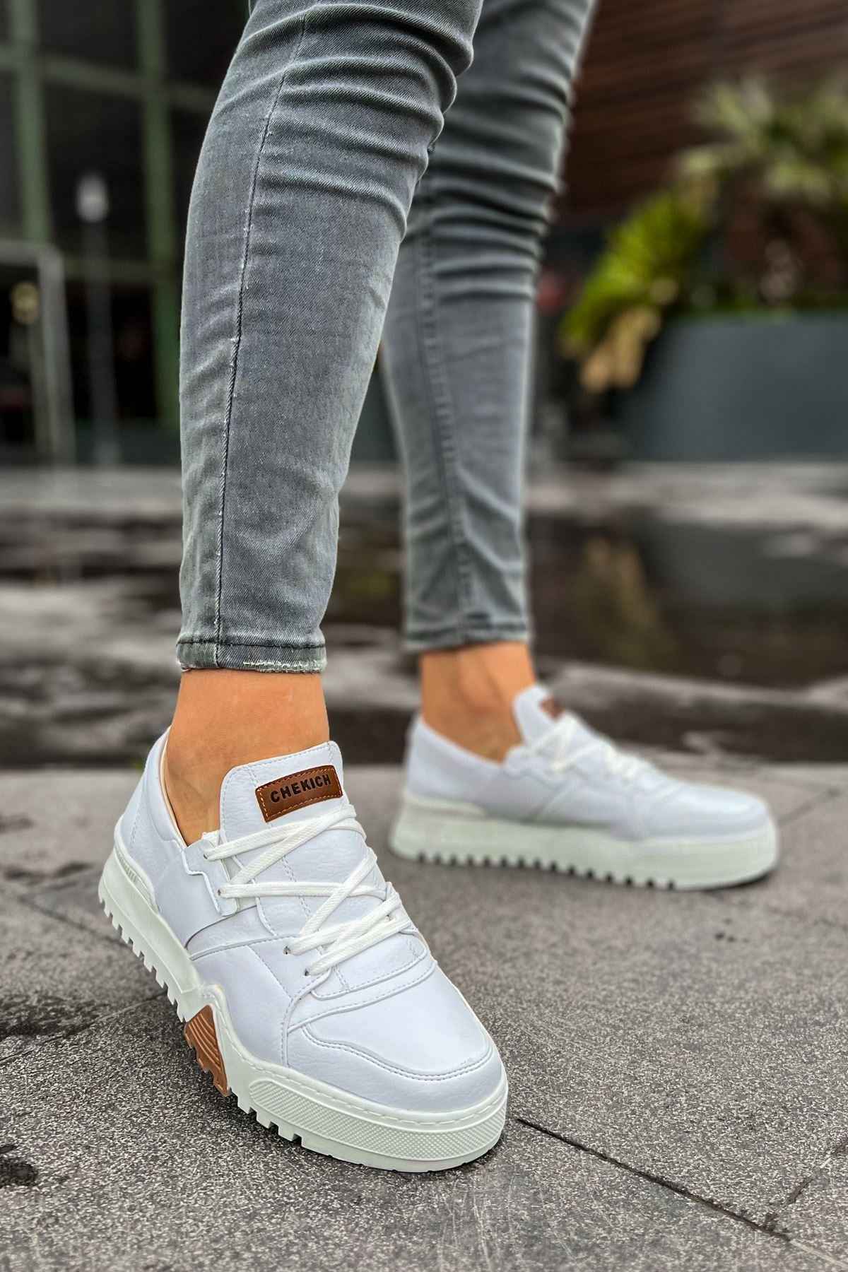 White lace-up casual sneakers with brown logo tag