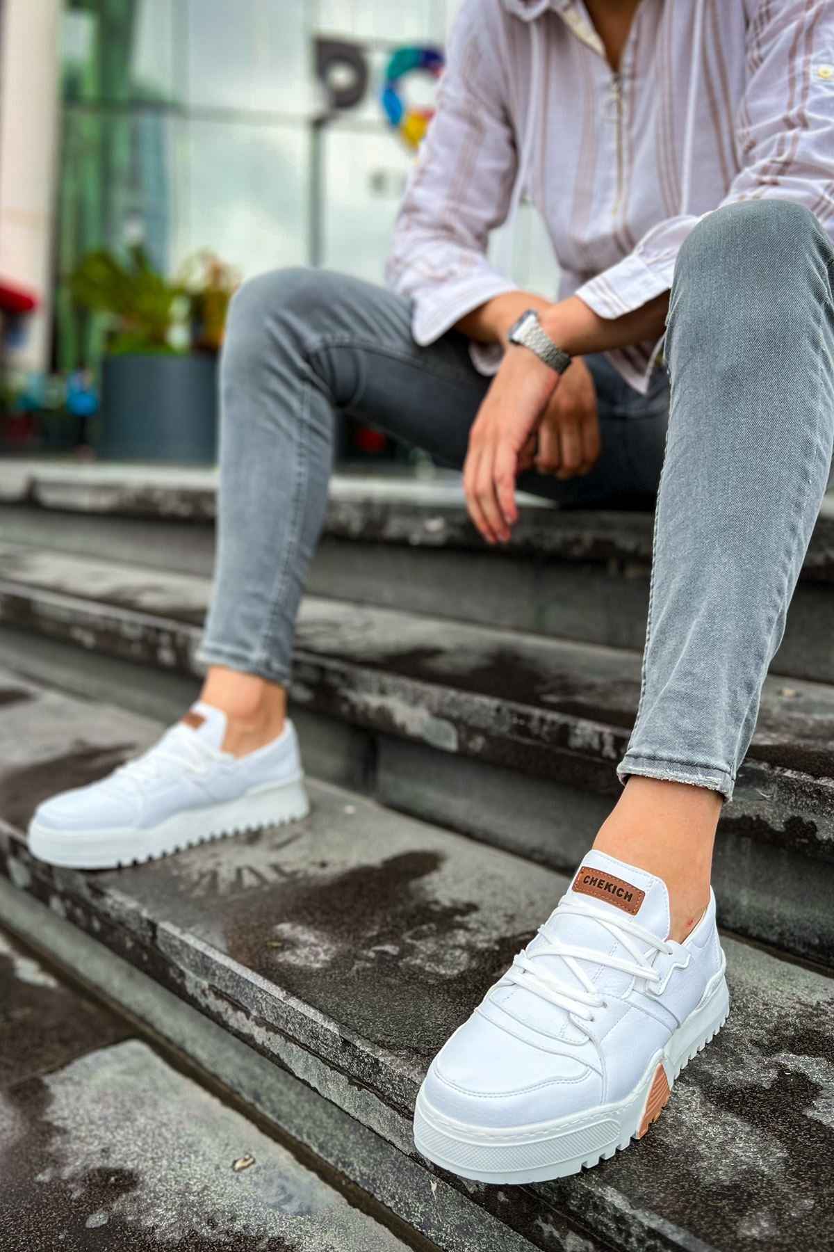 White lace-up sneakers with brown heel tab and gum sole