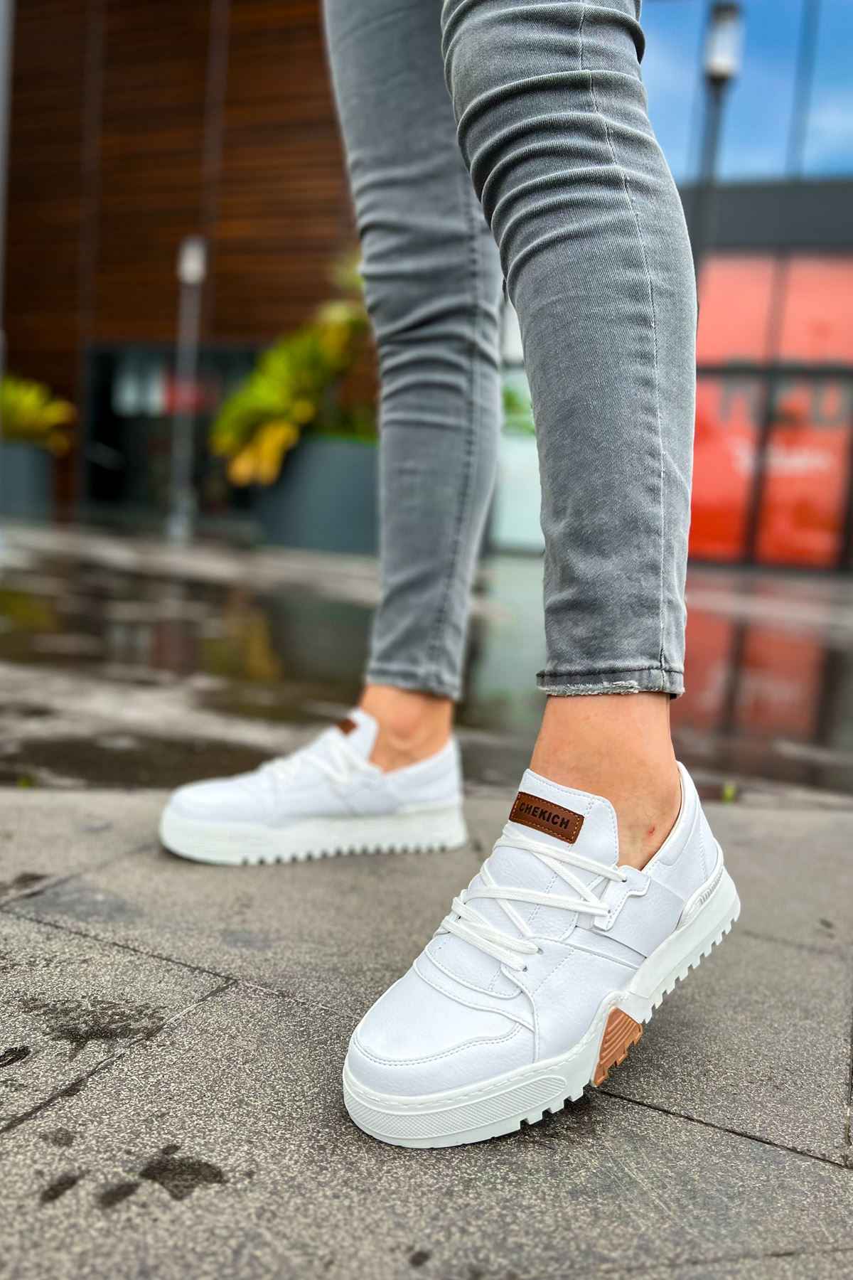 White lace-up sneakers with textured sole and brown side accents