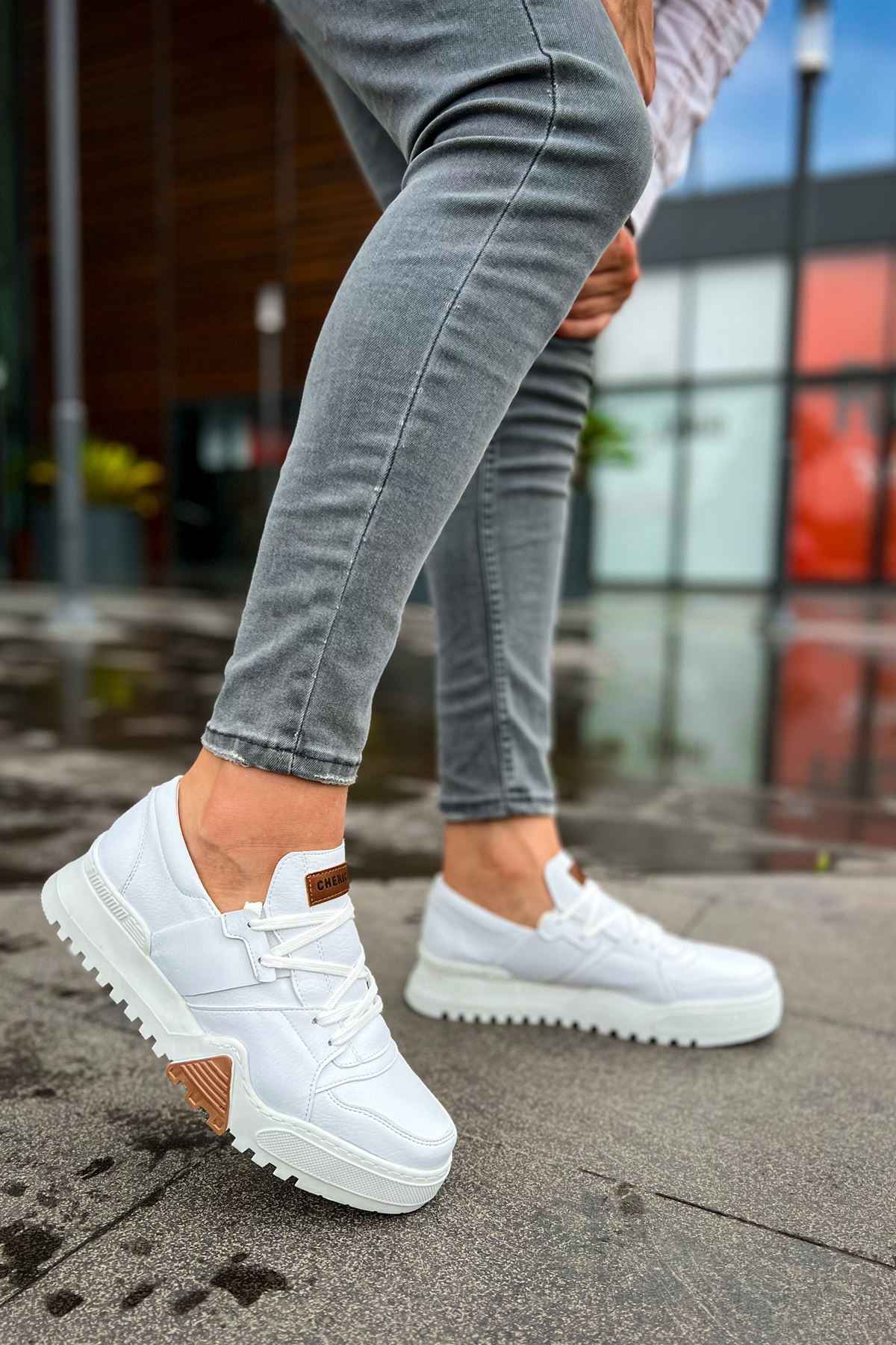 White lace-up sneakers with brown logo patch and rubber sole
