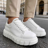 White low-top lace-up sneakers with smooth leather-look uppers and platform sole.