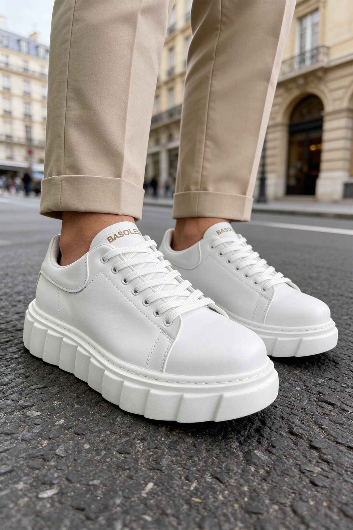White low-top lace-up sneakers with smooth leather-look uppers and platform sole.