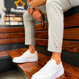 Men's white casual sneakers on wooden ledge, lace-up low-top profile