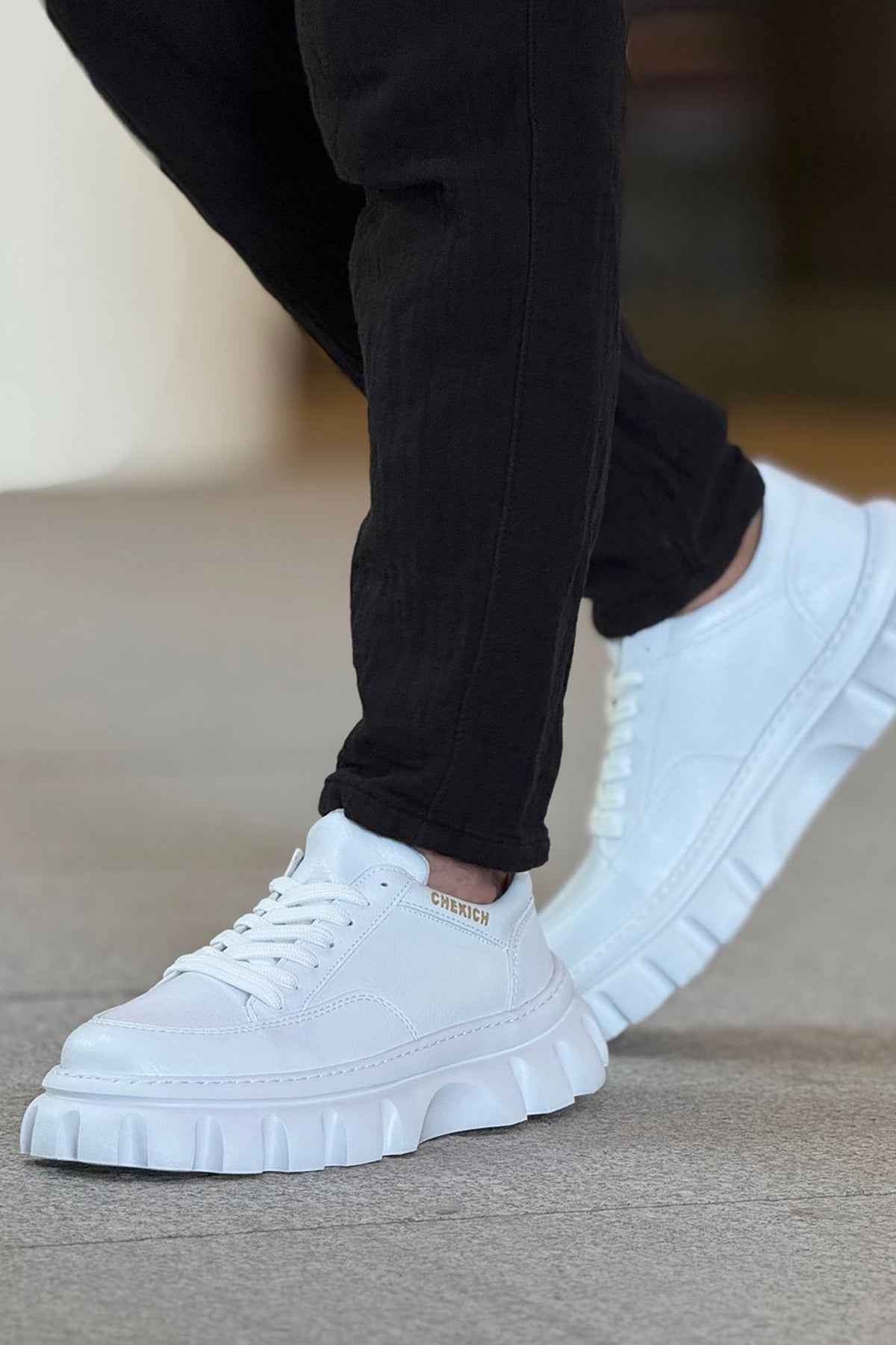 Men's white low-top sneakers with lace-up front and chunky white outsole