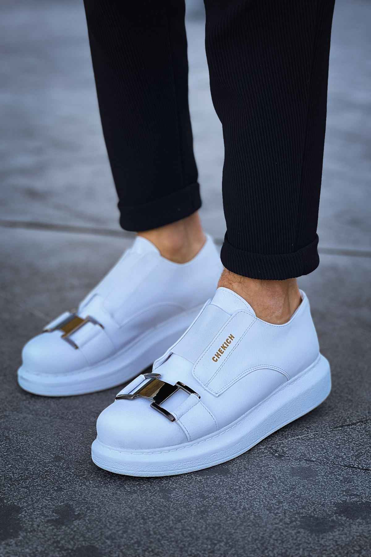Men's white sneakers with side buckle strap and smooth leather upper.