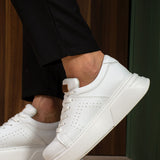 White low-top sneakers with lace closure and tan pull tab, side view