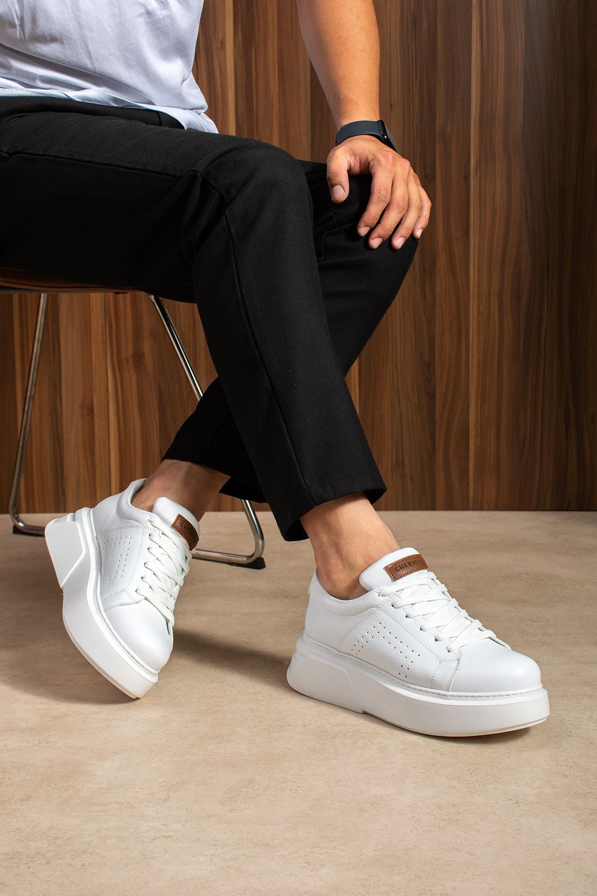 White lace-up sneakers with perforated detailing, tan heel tab and thick sole