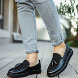 Men's black leather tassel loafers, side view, rounded toe, slip-on style