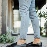 Men's black leather tassel loafers, paired view, low-profile sole