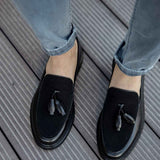 Men's black leather tassel loafers, close-up of tassel and rounded toe