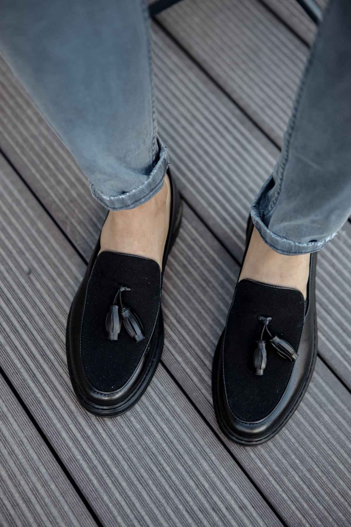 Men's black leather tassel loafers, close-up of tassel and rounded toe