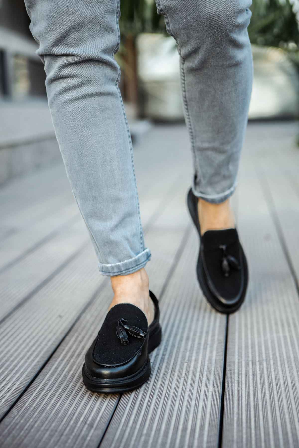 Men's black leather tassel loafers, on foot, rounded toe and low sole