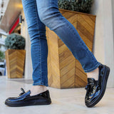 Black patent leather loafer with strap, low sole, and slight heel