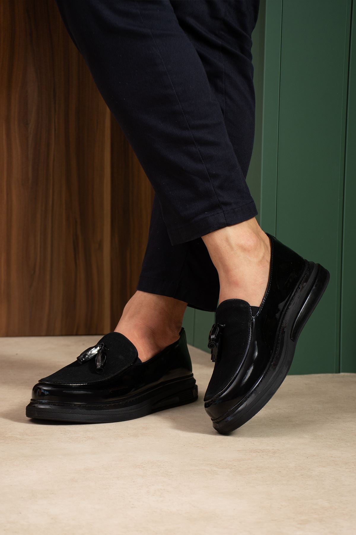 Men's black patent leather tassel loafers, side view with glossy finish