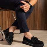 Men's black patent leather tassel loafers, front view with slip-on vamp