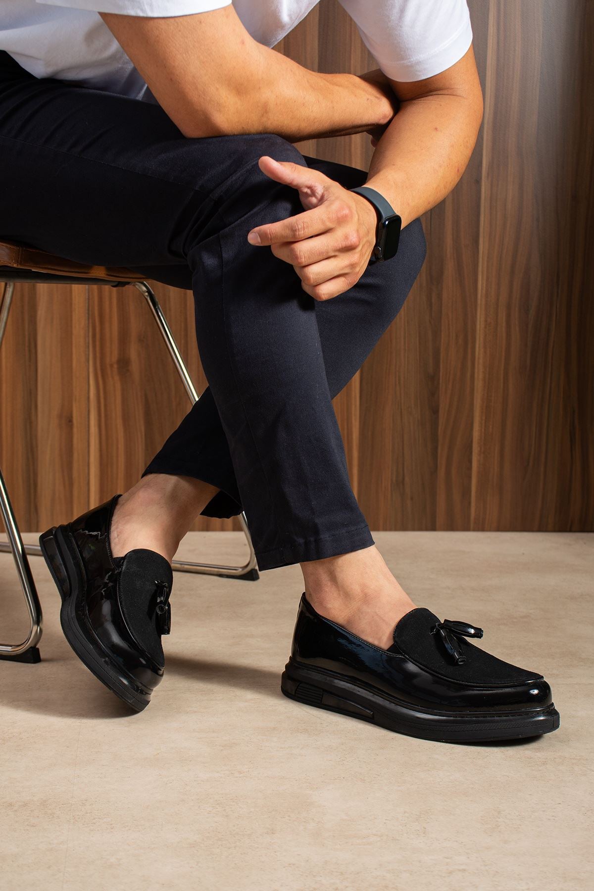 Men's black patent leather tassel loafers, front view with slip-on vamp