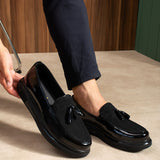 Men's black patent leather tassel loafers, close side profile with polished gloss