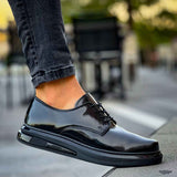 Men's black patent leather lace-up shoes, close side view with textured sole