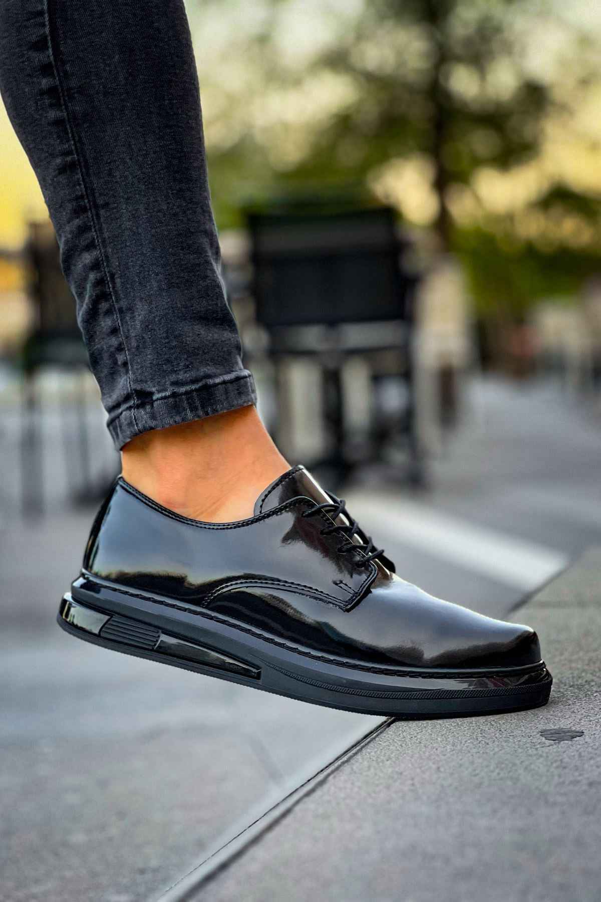 Men's black patent leather lace-up shoes, close side view with textured sole