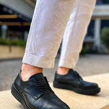 Black leather lace-up shoes with rounded toe and stitched detail, low-profile sole