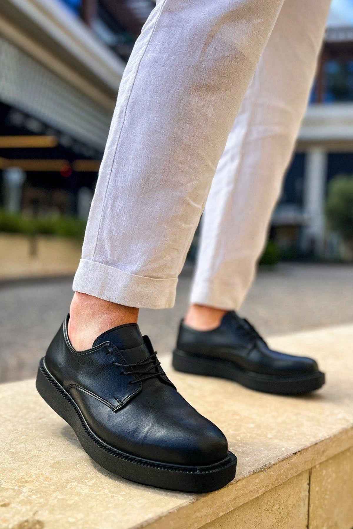 Black leather lace-up shoes with rounded toe and stitched detail, low-profile sole