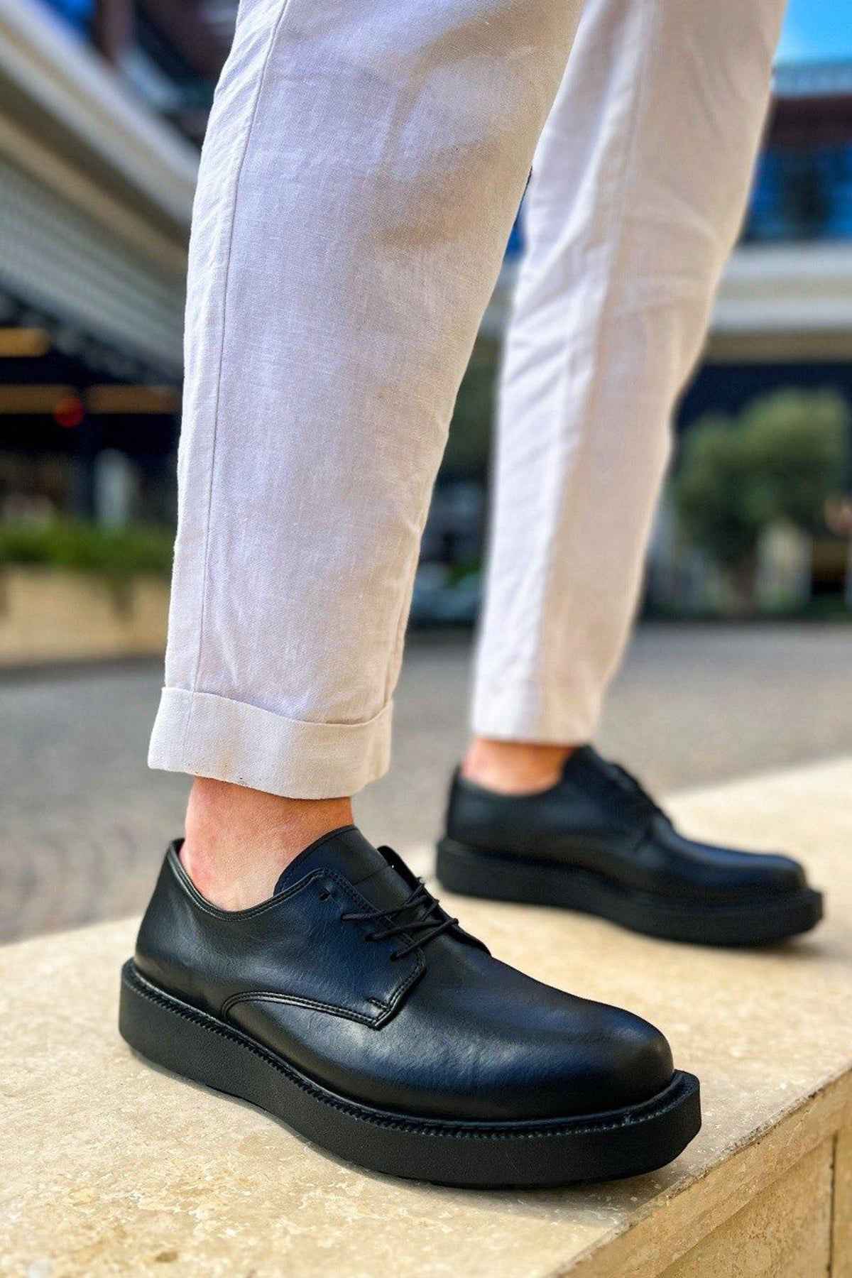 Black lace-up dress shoes with stitched upper and low-profile rubber sole