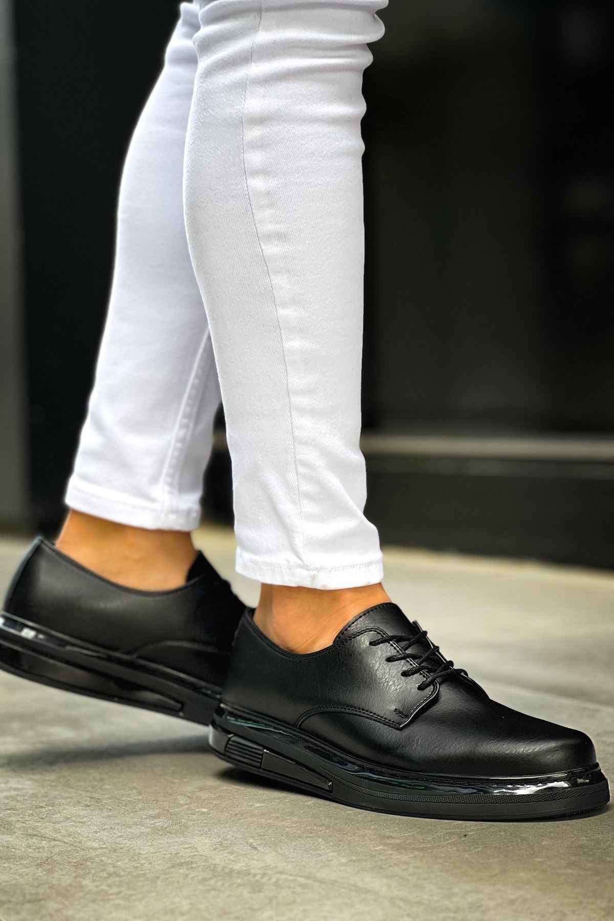 Men's classic black lace-up shoes, angled side view with textured outsole