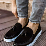 Men's black tassel loafers with white rubber sole, side view