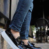 Men's black patent leather loafers with white sole, side view