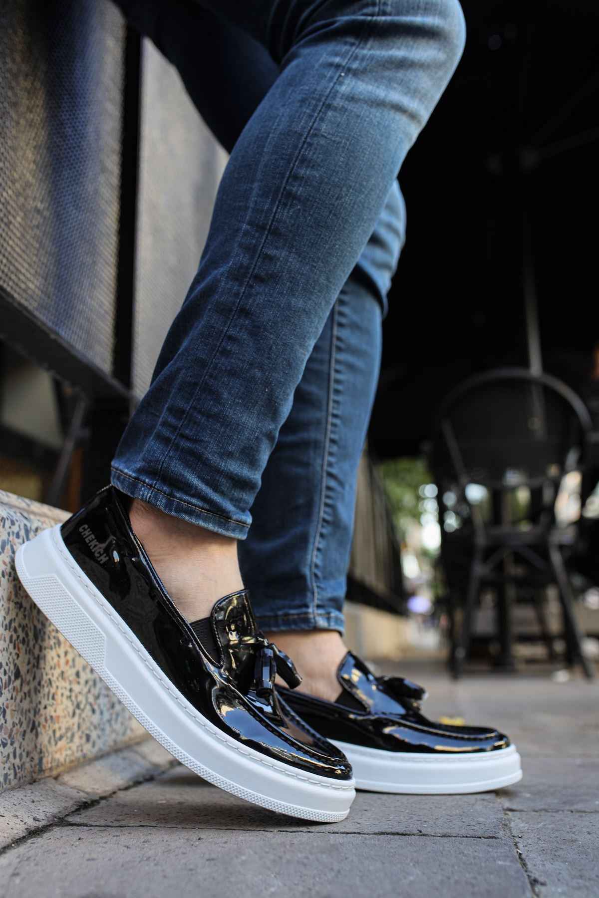 Men's black patent leather loafers with white sole, side view