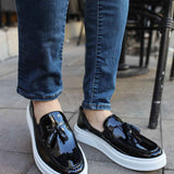 Men's black patent leather loafers with white rubber sole, front view