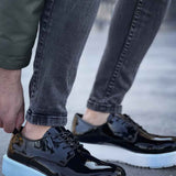 Men's black patent leather sneakers, side view, light blue sole and lace-up front