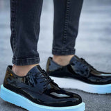 Men's black patent leather lace-up sneakers with light blue sole, front quarter view