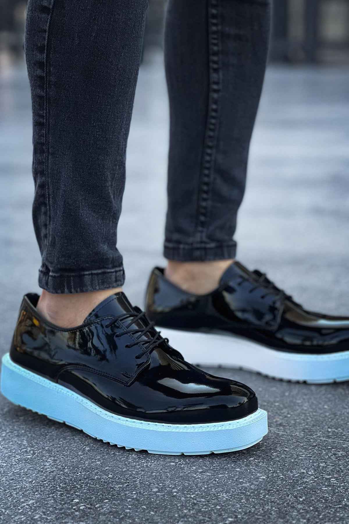 Men's black patent leather lace-up sneakers with light blue sole, front quarter view