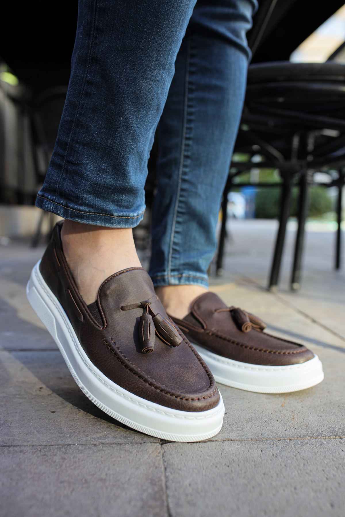 Brown loafers with tassel detail and slip-on design, white rubber sole.