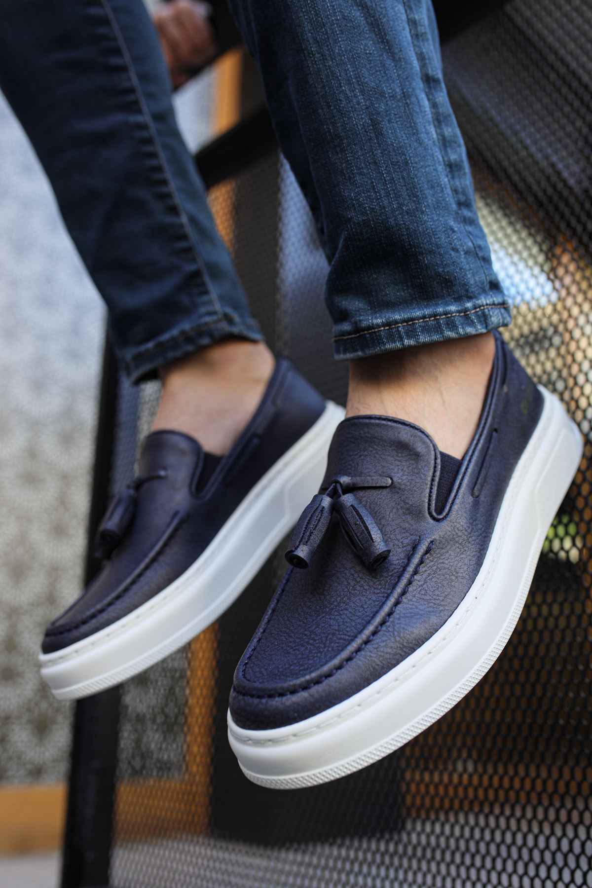 Navy suede loafers with tassel detail and white contrast rubber sole