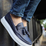 Navy suede slip-on loafers with tassel detail and thick white sole trim