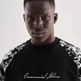 Black oversized T-shirt with floral shoulders and centered script logo