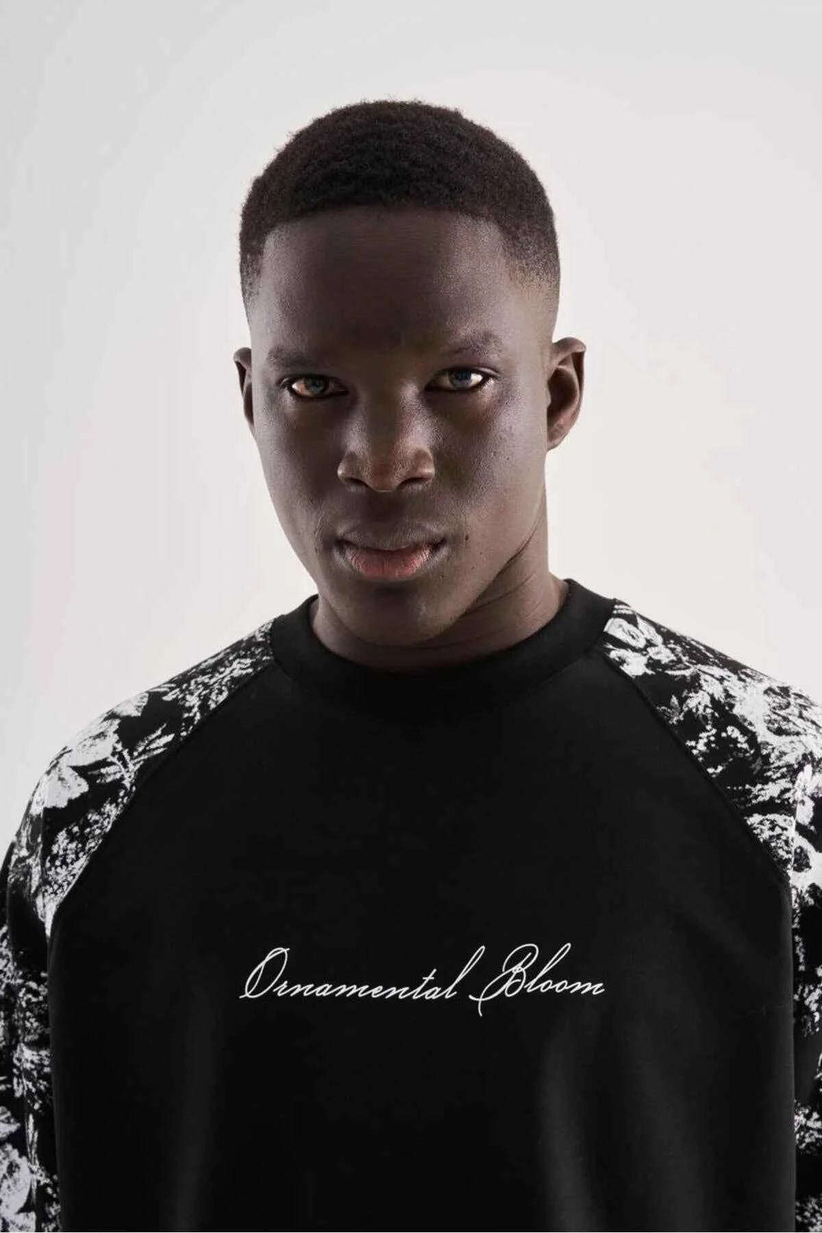 Black oversized T-shirt with floral shoulders and centered script logo
