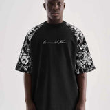 Black oversize men’s T-shirt with floral sleeve print and centered script graphic