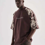 Brown oversize T-shirt with floral print sleeves and script logo on chest