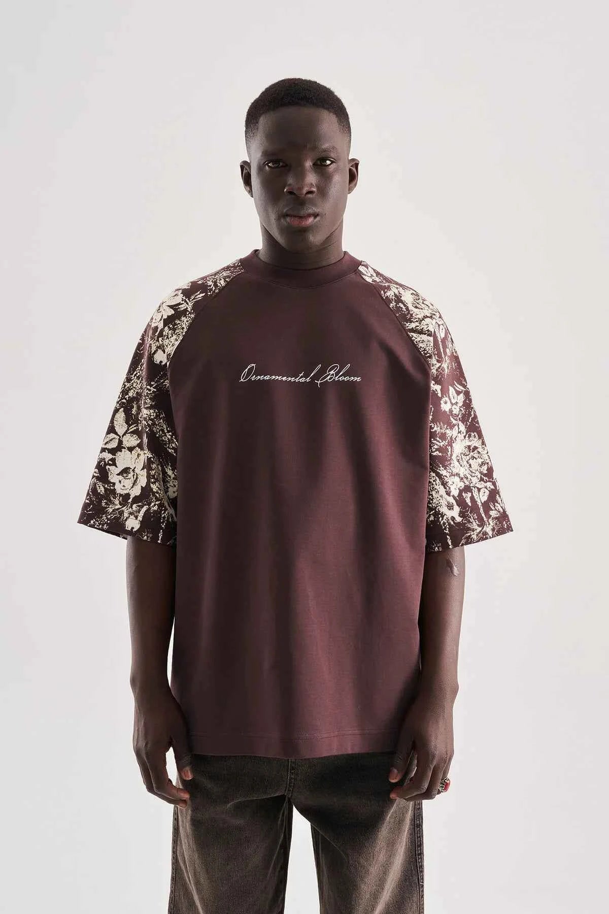 Brown oversize T-shirt with floral print sleeves and centered script graphic