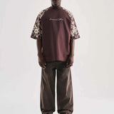 Brown oversize T-shirt with floral print sleeves and chest script graphic