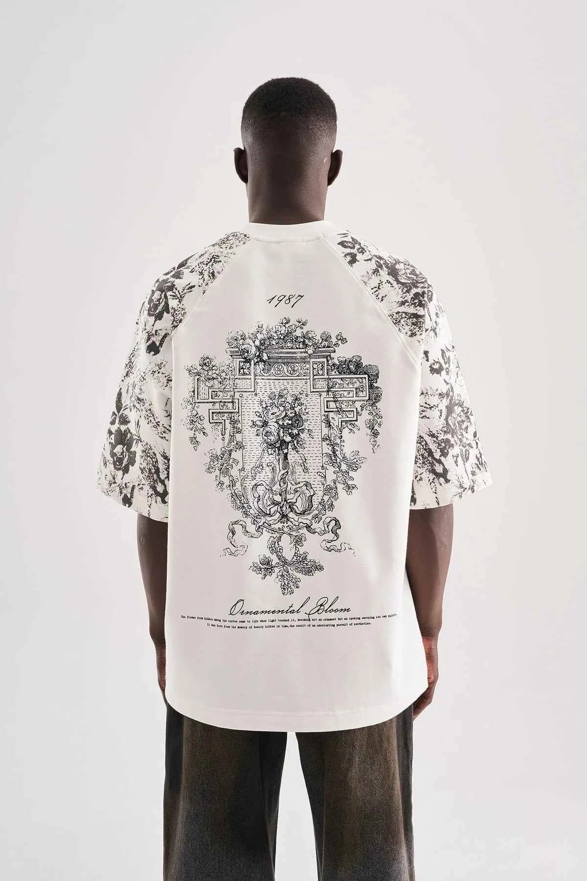 White oversized T-shirt with large black floral crest graphic on back
