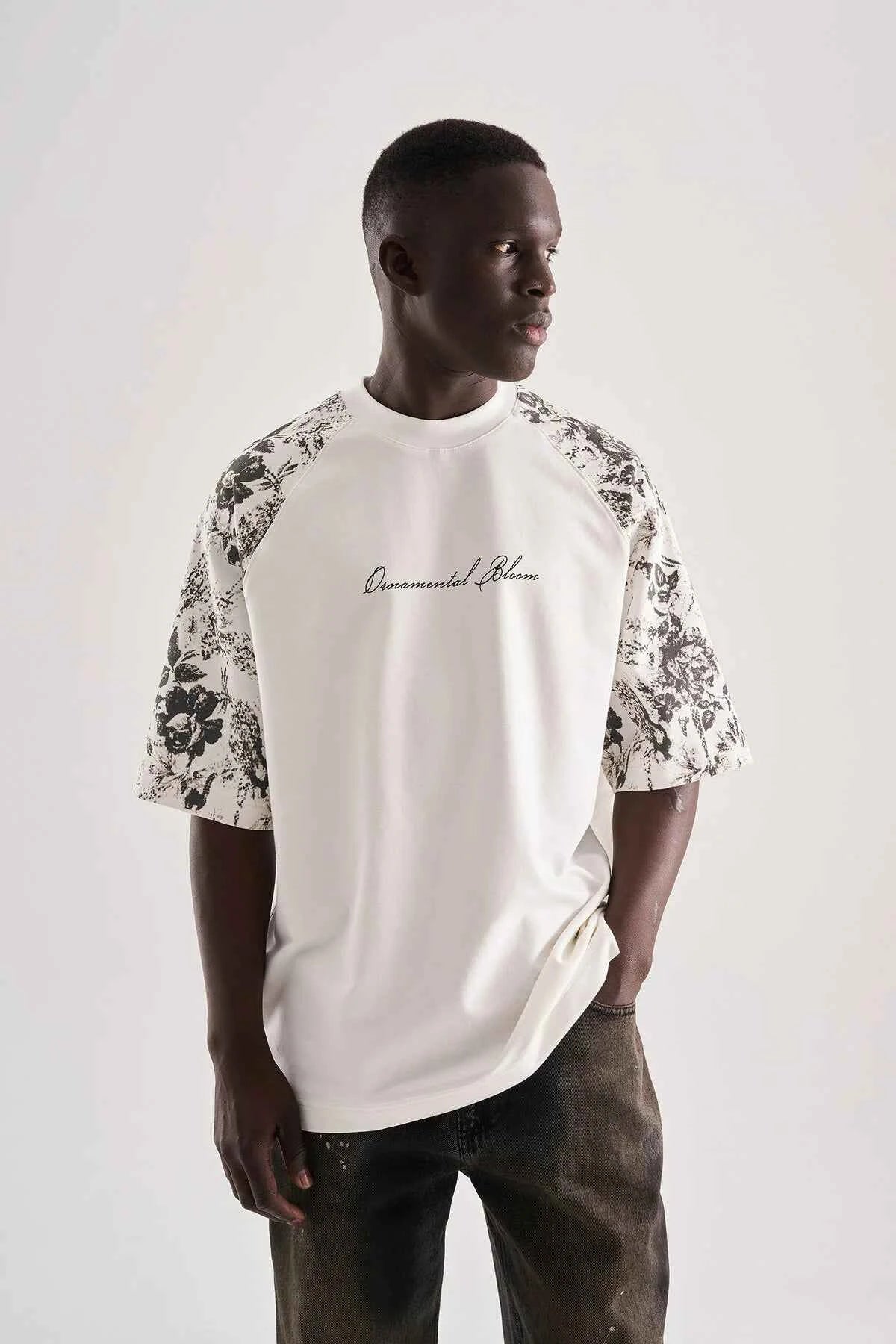 White oversized T-shirt with black floral print sleeves and FLW logo