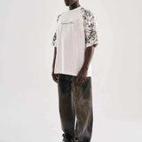 White oversized T-shirt with black floral sleeve print, side view