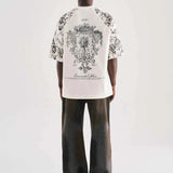 White oversized T-shirt with large black floral crest graphic on back, rear view