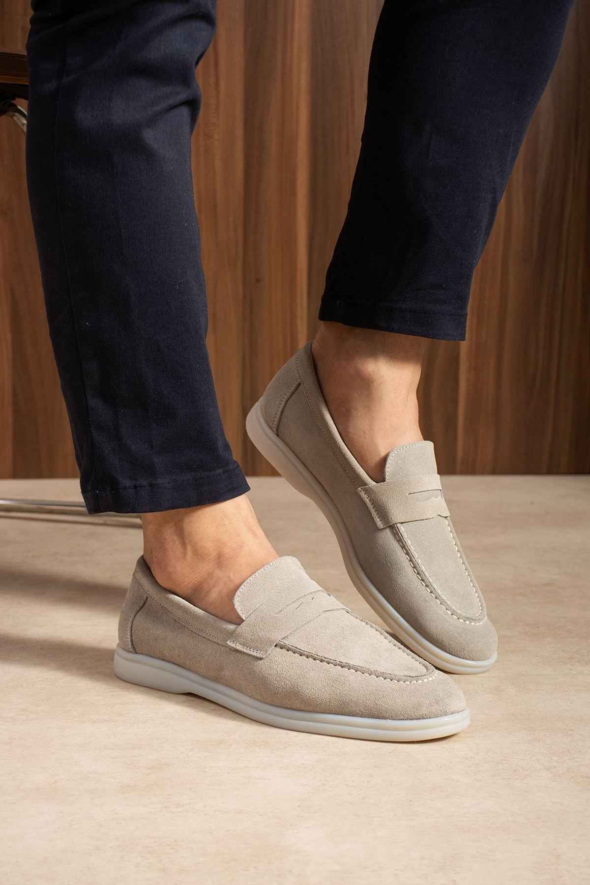 Beige leather loafers with moc-toe stitching and cushioned collar
