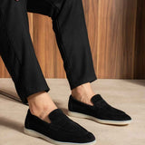 Black slip-on loafers with strap detail and white rubber sole