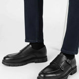 Black leather monk strap shoes with double side buckles, worn with jeans